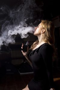 A woman is smoking a vape